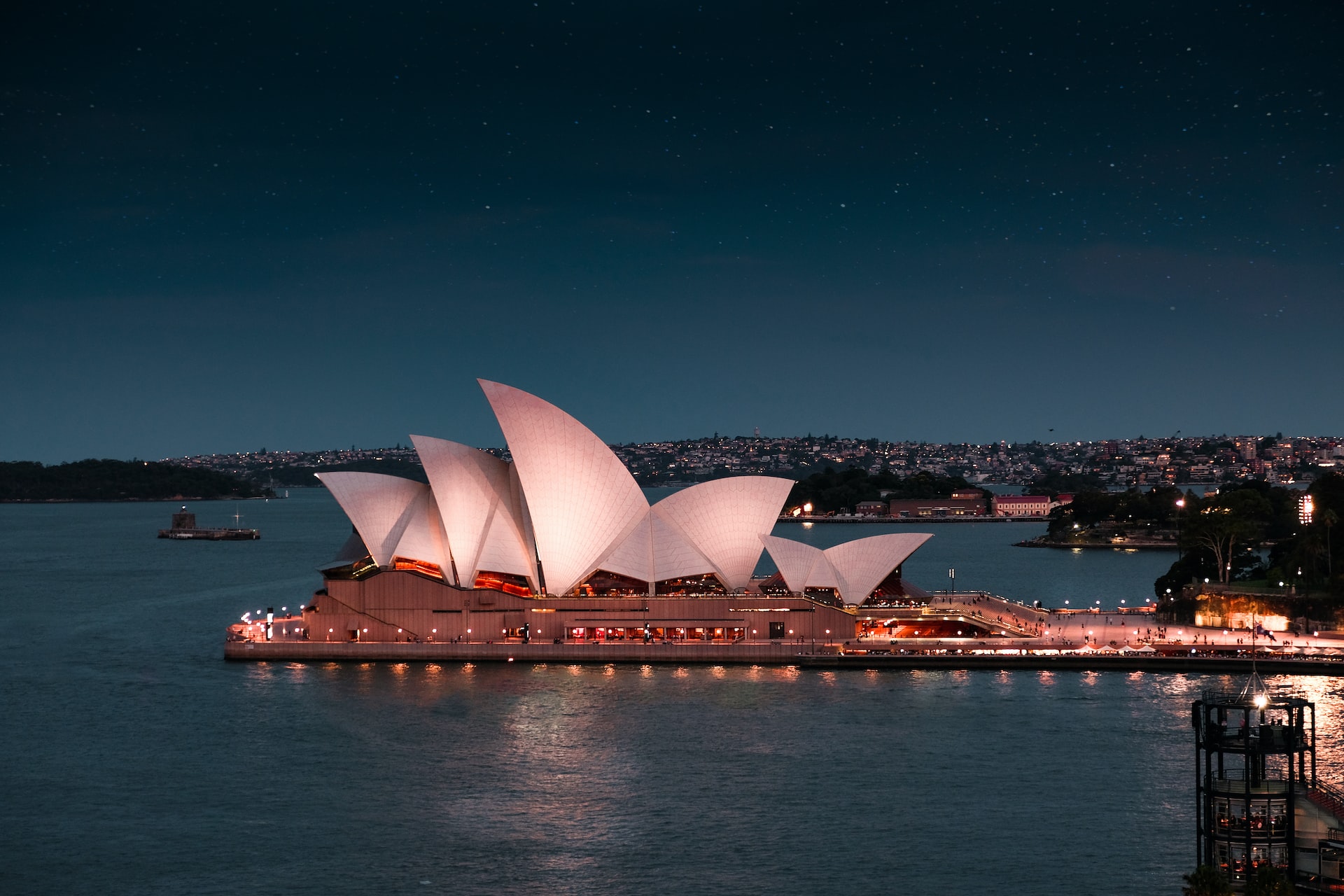 An image of the Sydney Opera House, lit up at night.