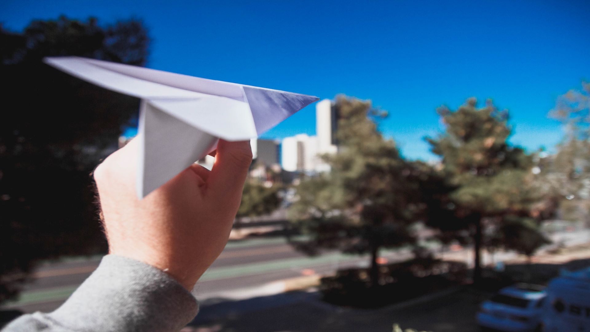 A hand holds a paper plane.