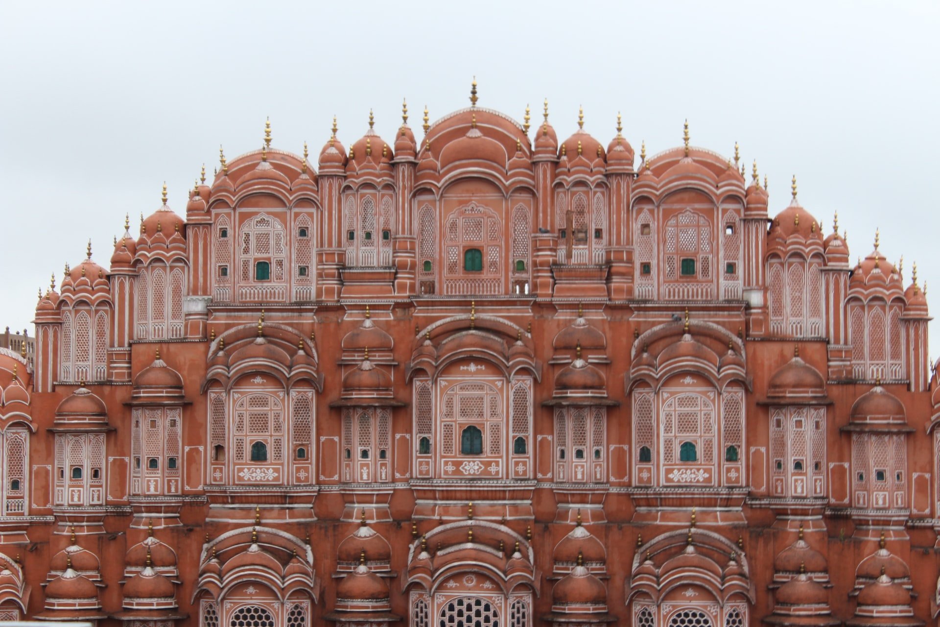 An image of a grand building in a pink hue, found in the city of Jaipur, also known as the 'Pink City'.