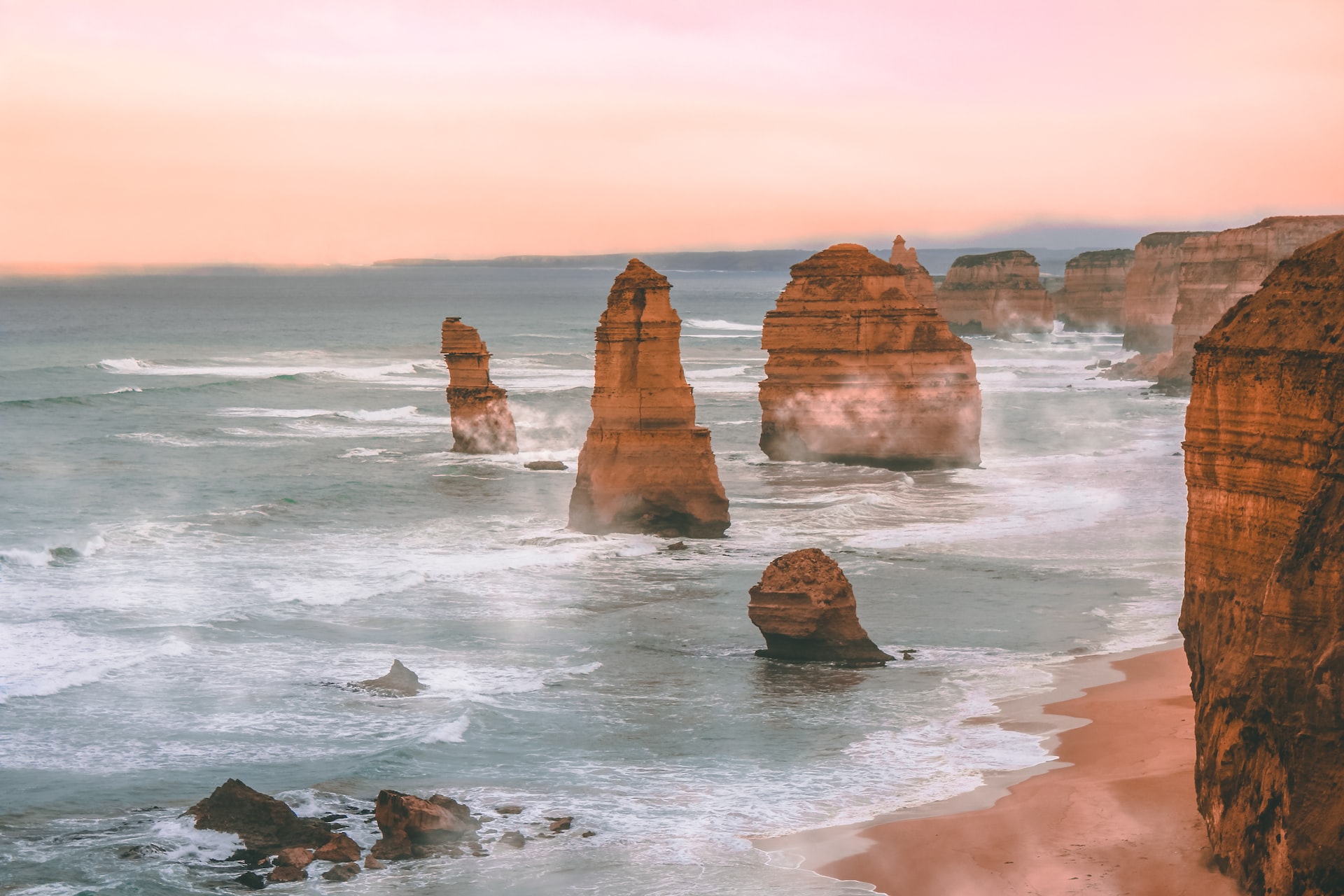 An image of the rocks known as the Twelve Apostles in Princetown, Australia, with waves crashing in the foreground.