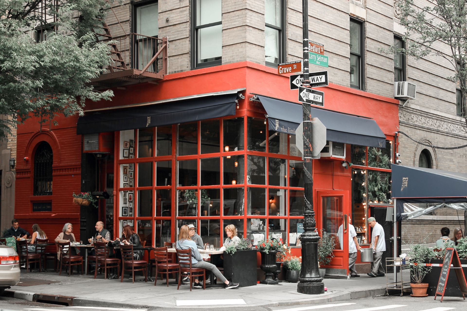 The outside of a classic New York apartment building, on the corner of the street.