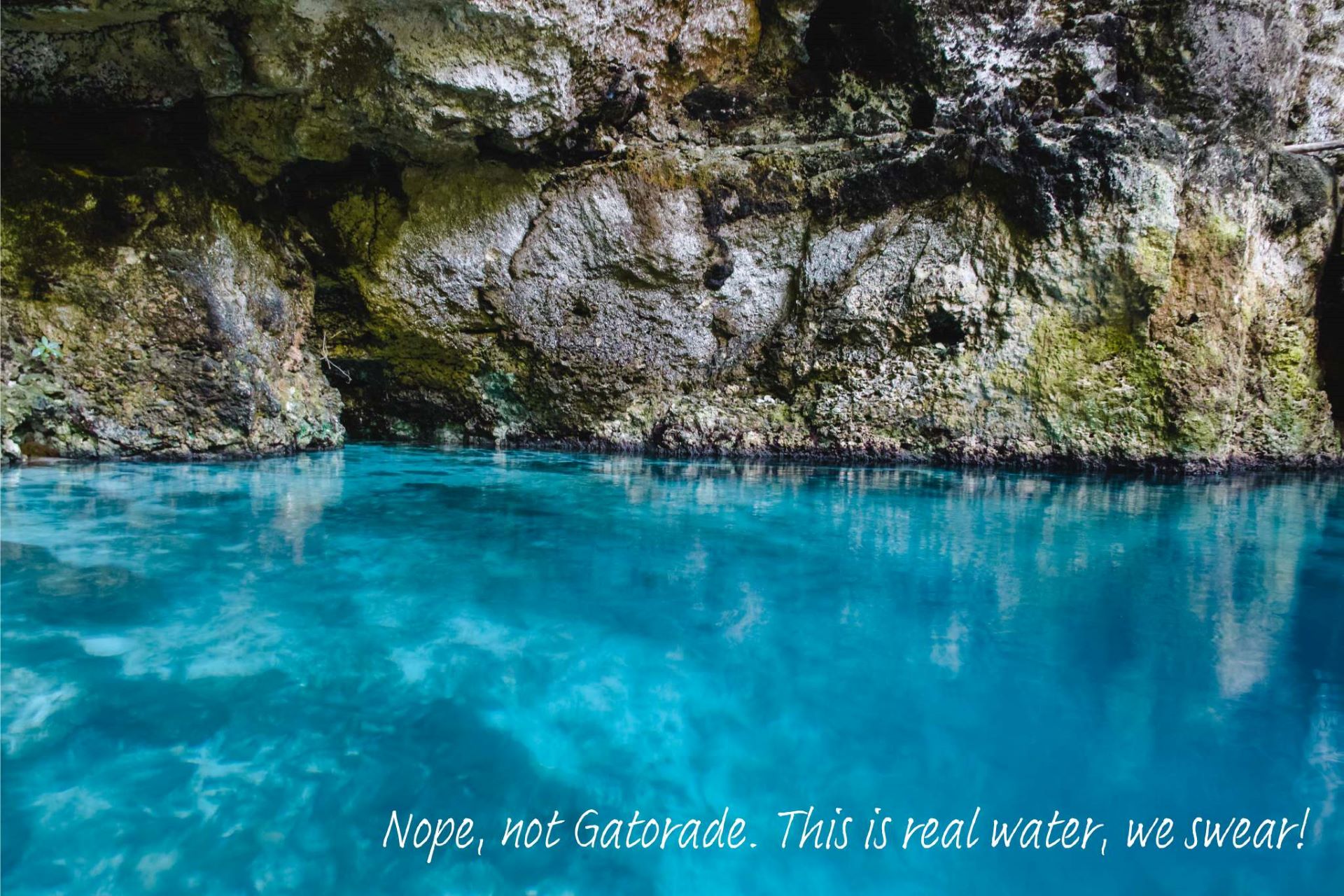 The inside of Hoy Azule, a cenote with bright blue water in the Dominican Republic.