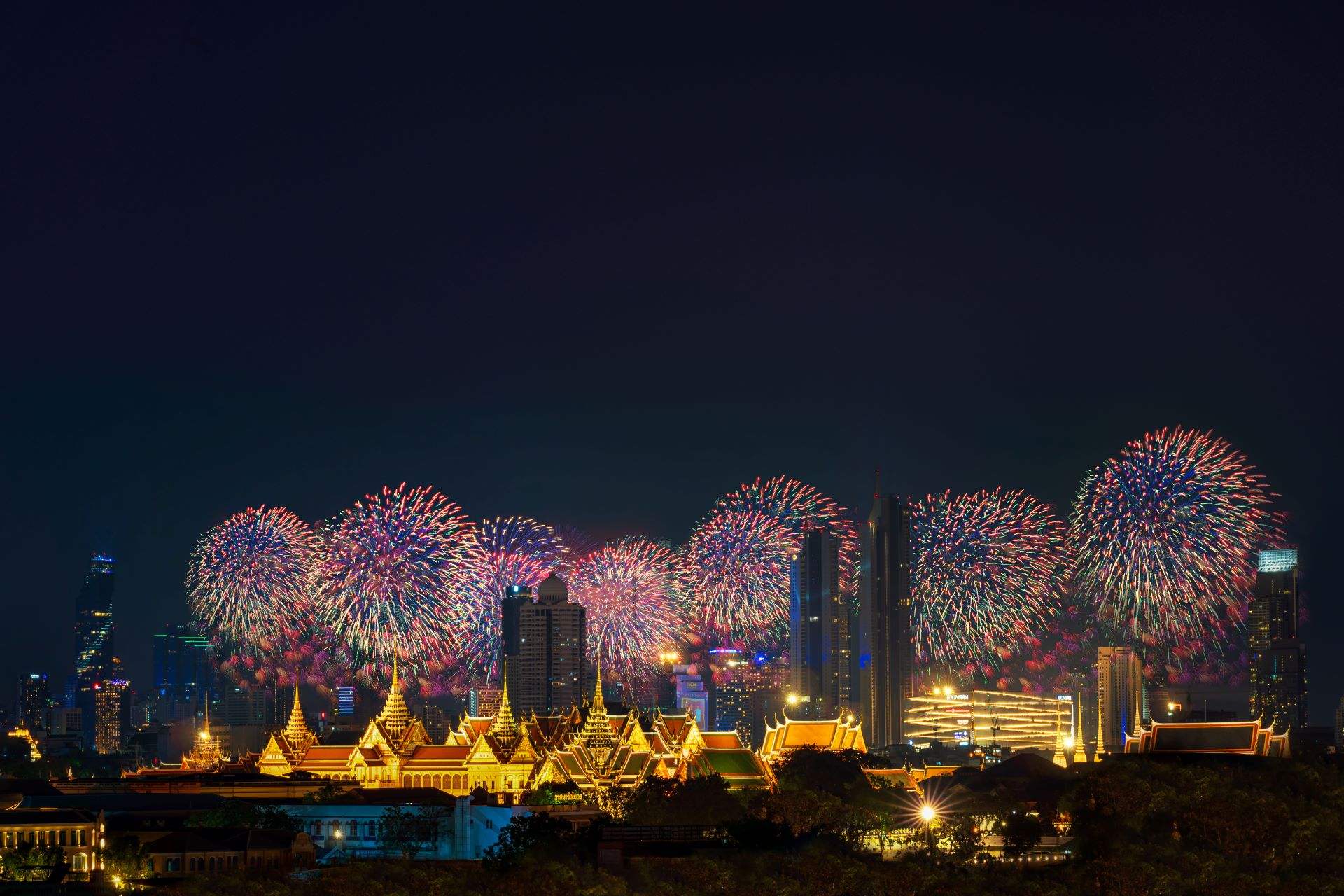 The Grand Palace in Bangkok is lit up fireworks in the night sky.