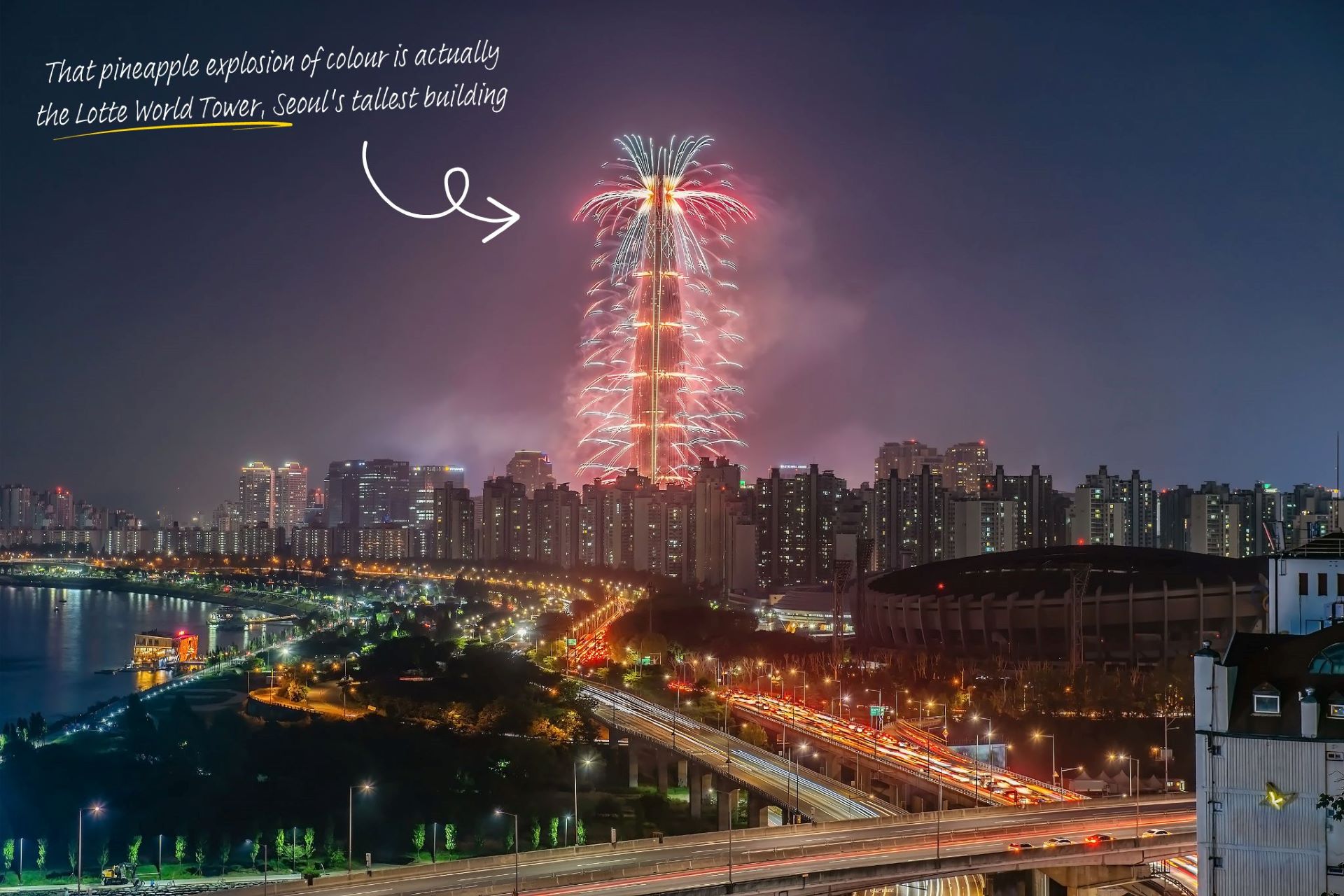 Lotte World Tower in Seoul is lit up at night by fireworks.