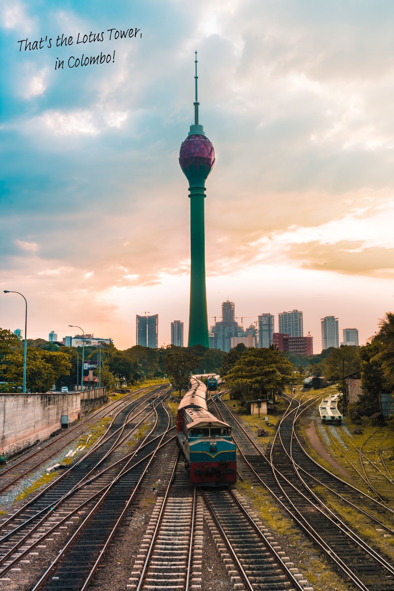 A train heads into Colombo, Sri Lanka, the Lotus Tower rising in the distance.