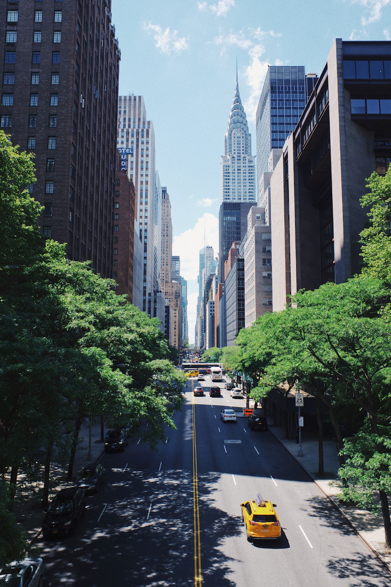 Looking down a long street in downtown New York, the Empire State building in the distance.