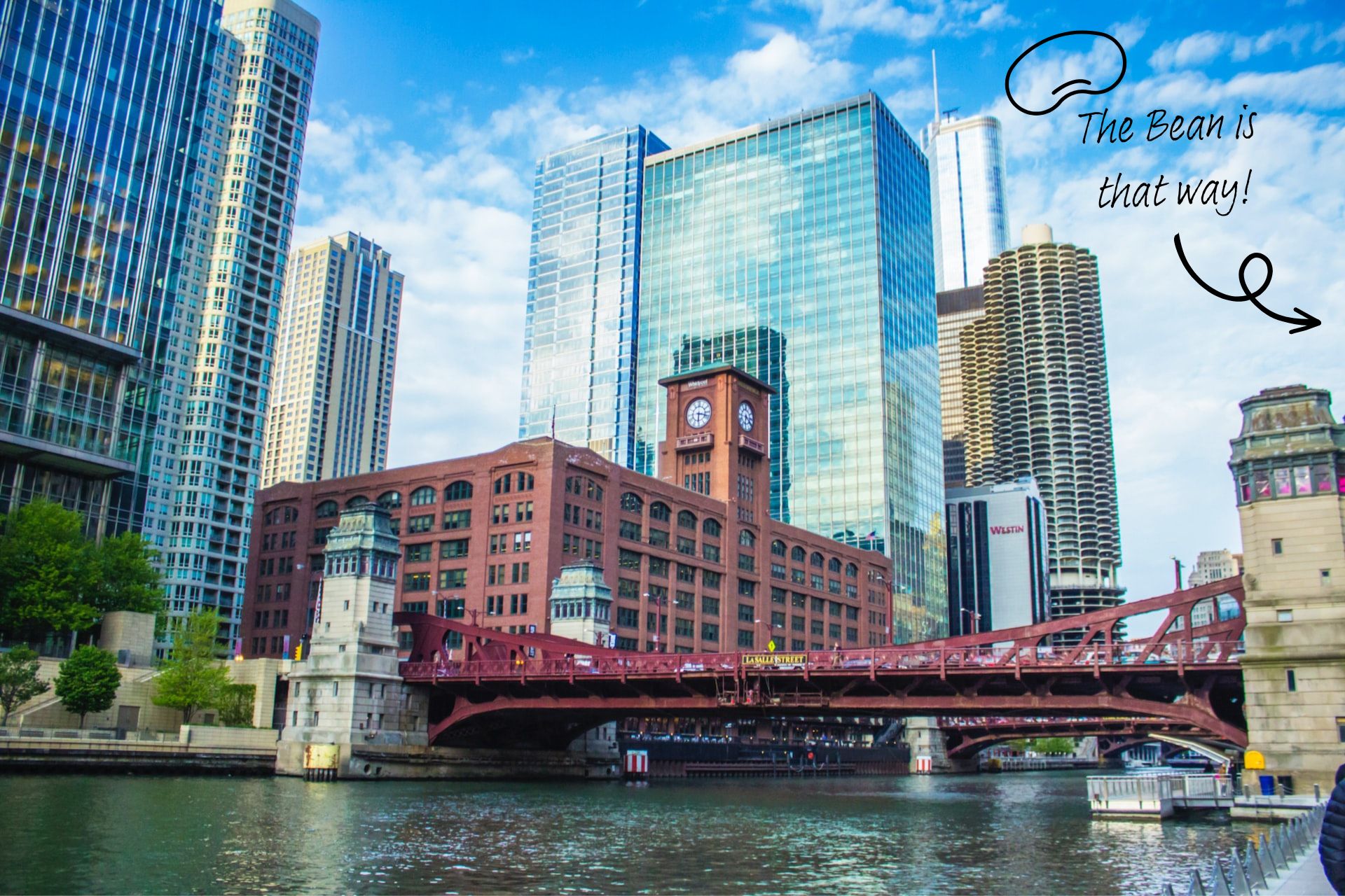 A low angle shot of a bridge crossing the Chicago River in Chicago, Illinois. Skyscrapers rise beside on either side.