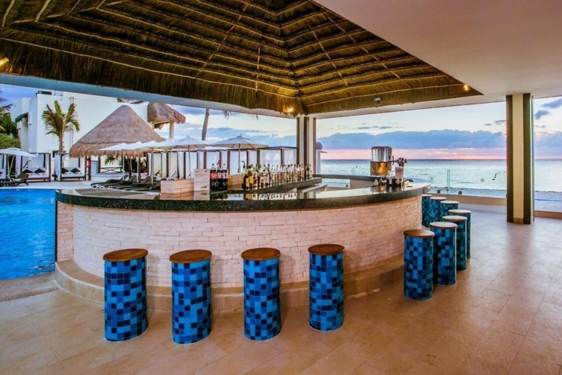 The pool bar at Desire Resort Cancun, the ocean in the background.