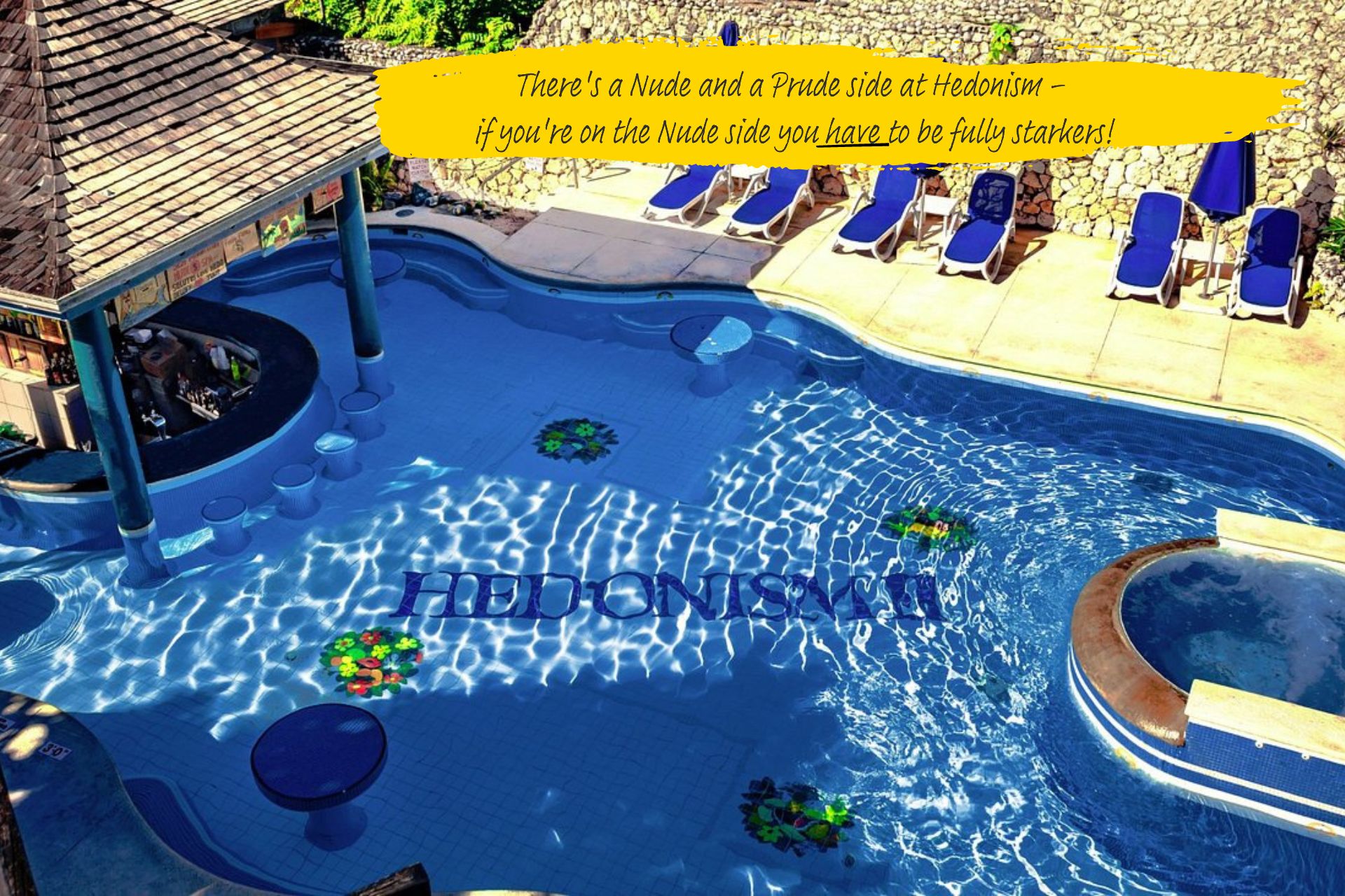 The pool at Hedonism II in Jamaica. Sunloungers sit around the edge, and the resort's name runs across the base of the pool.