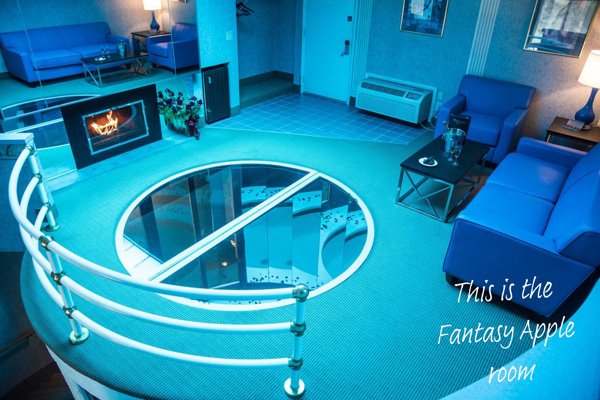 The blue 'Fantasy Apple' room at the Pocono Palace Resort, Philadelphia. A hole in the centre of the room, covered by glass, allows you to see down into the hot tub below.