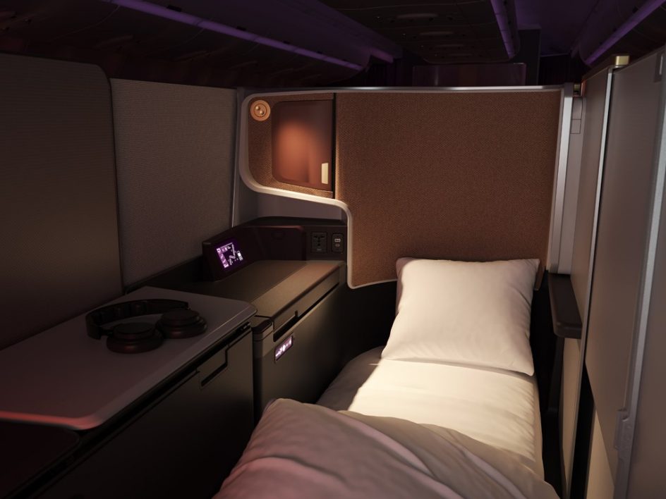 An Upperclass Suite on the A330neo. A single bed in an enclosed, private space with a large, long table running alongside it.