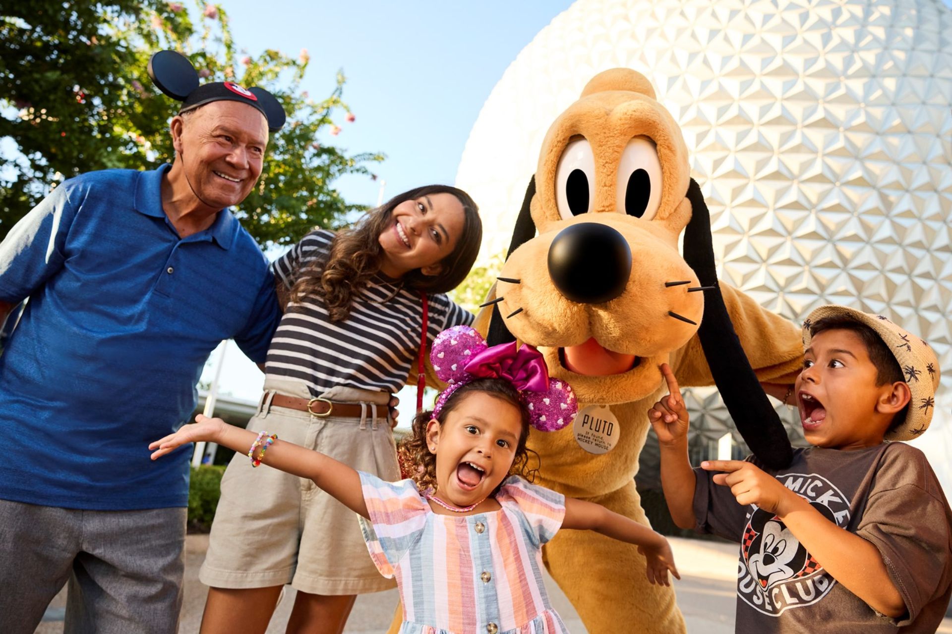 A family pose with Pluto in EPCOT at Walt Disney World, Florida.