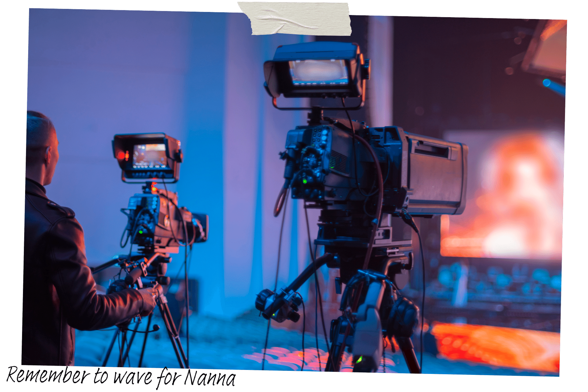 A generic image showing a man stood behind two large cameras on tripods, looking towards a film set.