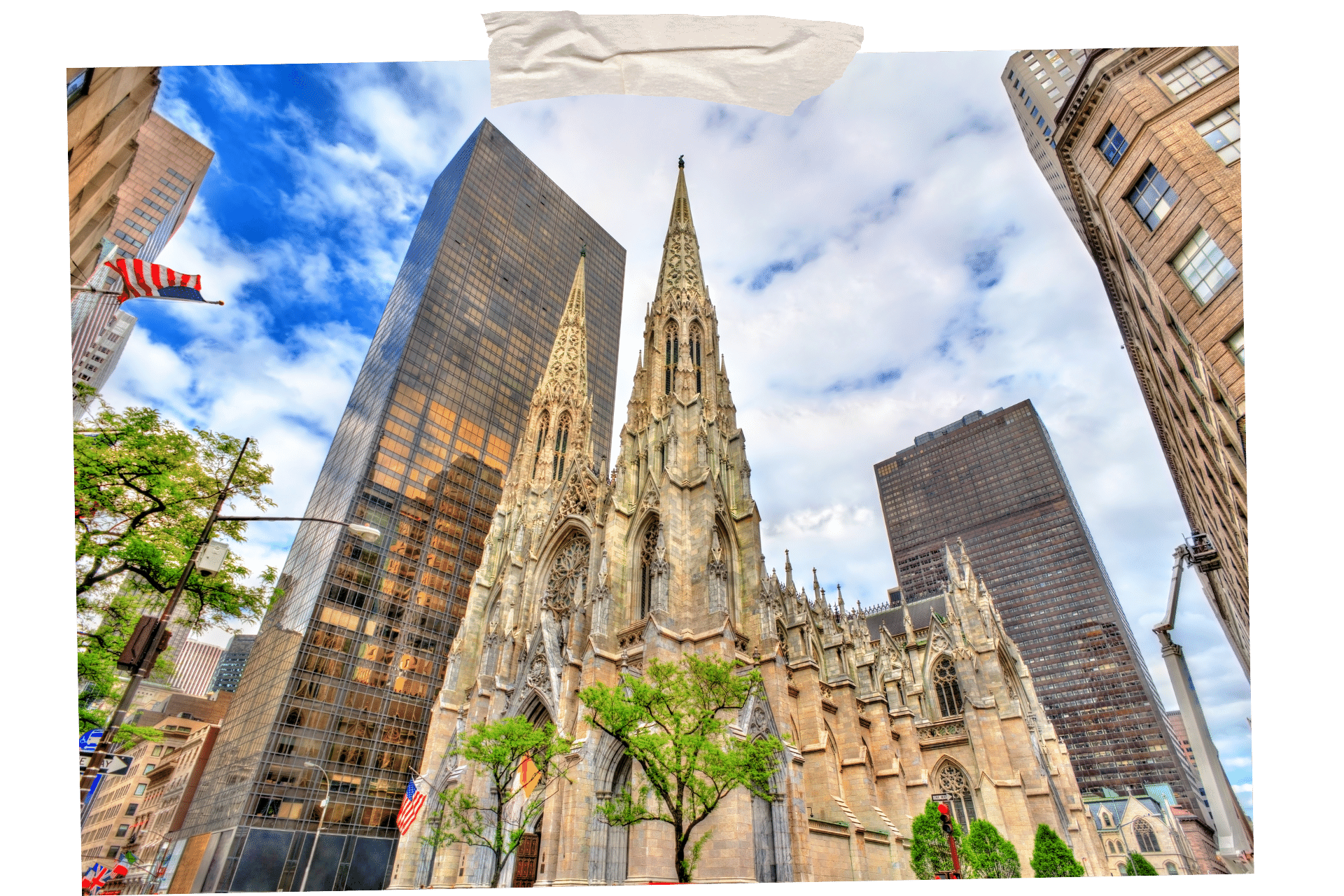St Patrick's Cathedral is one of the must-visit historic sites in NYC. Image shows the Gothic facade of the cathedral from ground level, with two spires reaching up into the sky. Metal and glass skyscrapers surrounding the building on all sides.