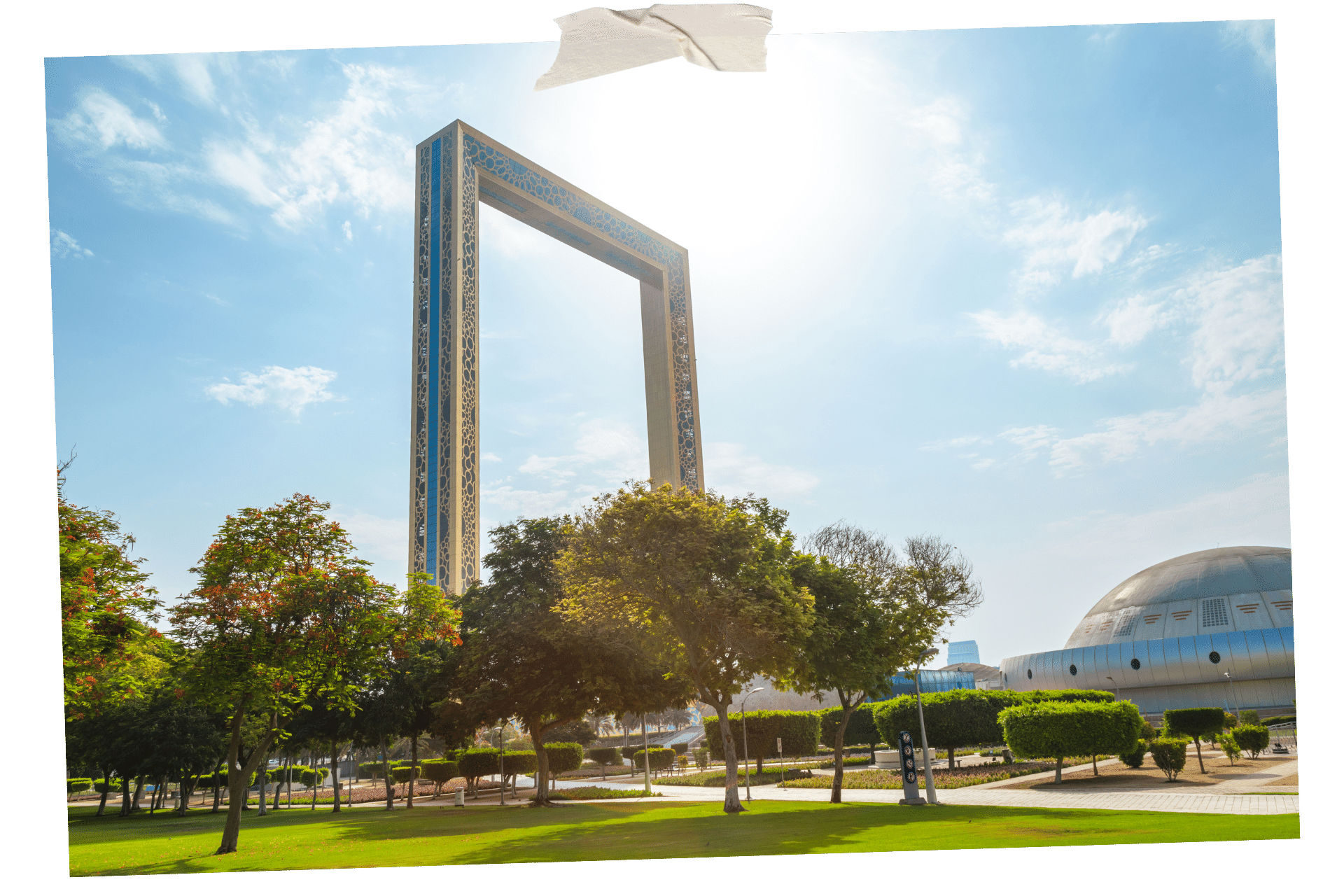 The Dubai Frame is one of Dubai's hidden gems. An image, scrapbook style, shows a large metal frame rising into the sky, with a lawn and trees surrounding its base.